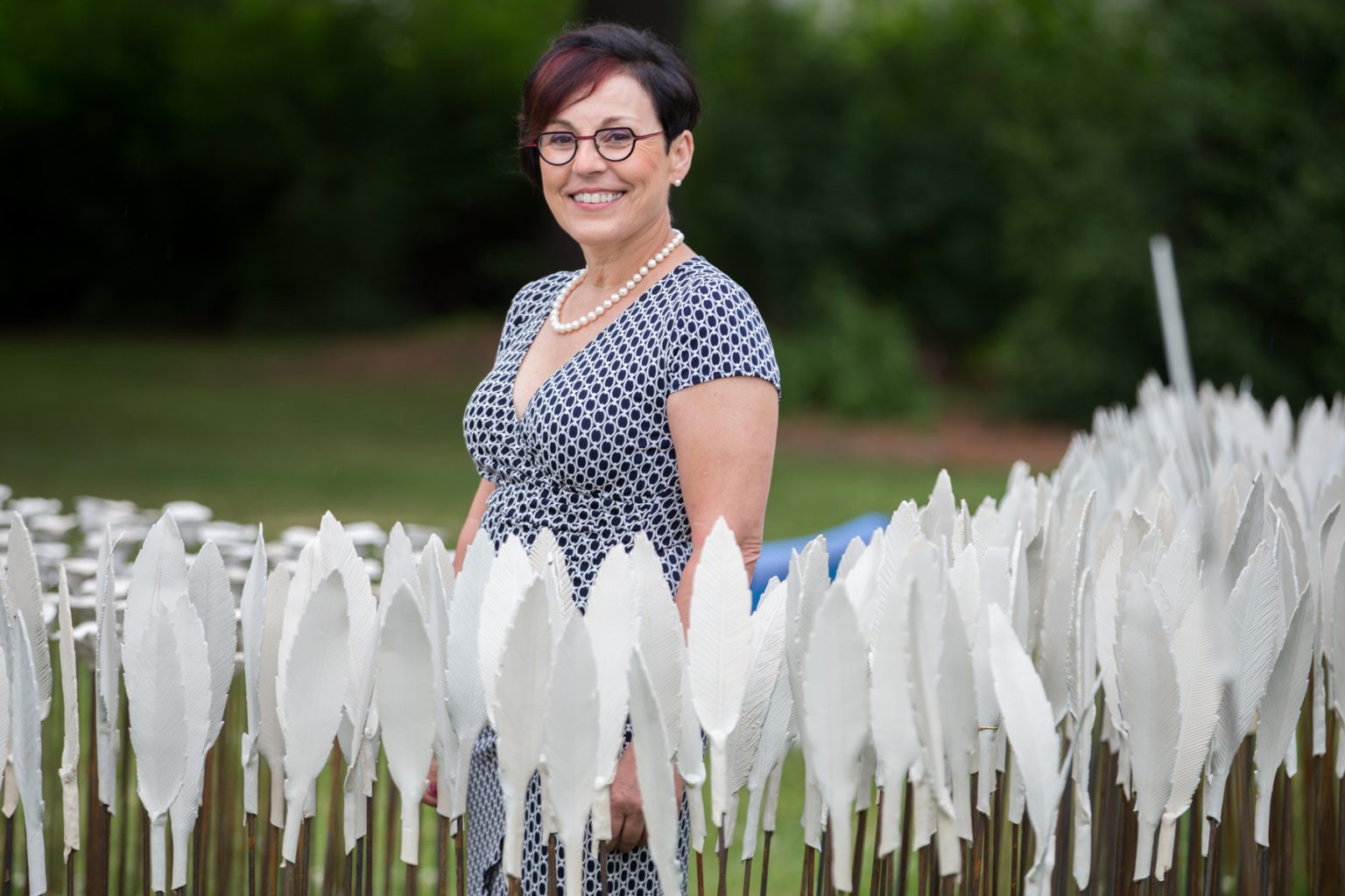 Artist Hilde Lambrechts stands among the ceramic feathers of her art installation Compass: Peace in All Directions on the front lawn of Canada?s Centre for Geography and Exploration, during the exhibit?s launch on Wednesday, June 27. (Photo: Ben Powless/Canadian Geographic)