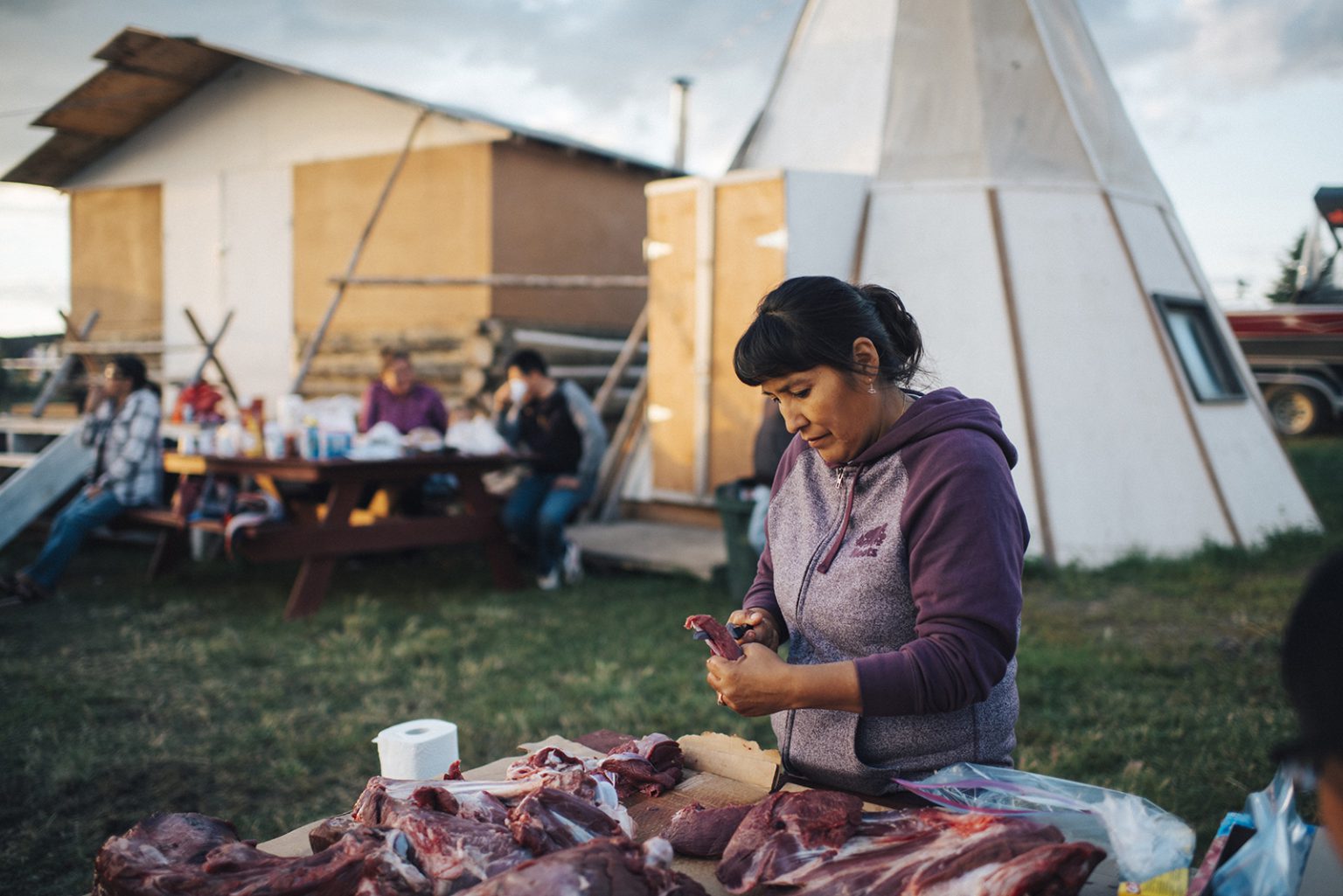 Diane Andre prepping caribou meat for her uncle's funeral.