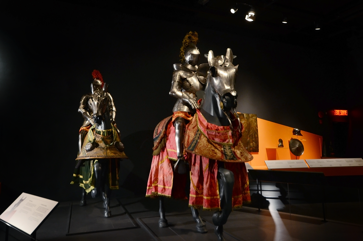 Museum display featuring two life-size knights in full body armour on horseback 