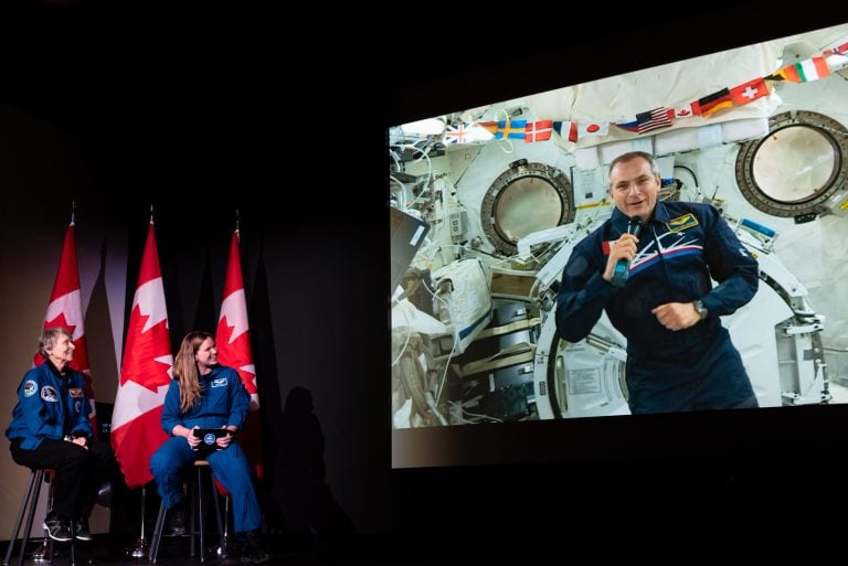 Roberta Bondar, Jenni Sidey-Gibbons, and David Saint-Jacques (appearing via video link from the International Space Station) talk to students at the Canada Museum of Science and Technology