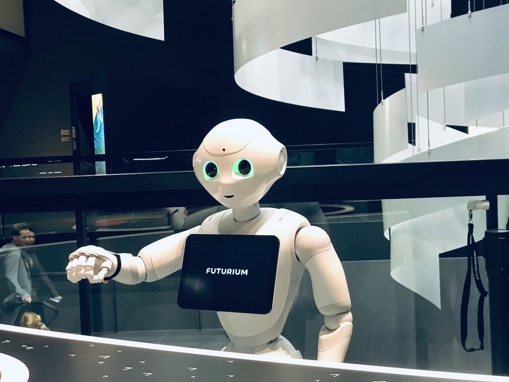A robot with a tablet stands at a reception desk