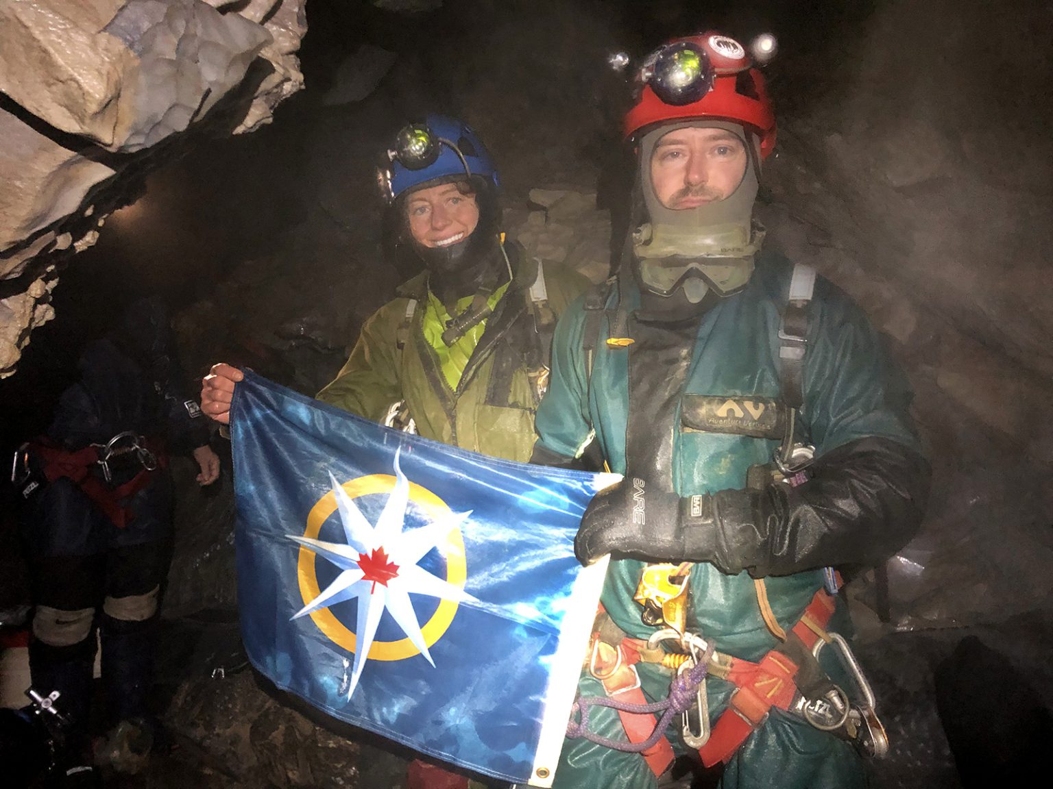 Kathleen Graham and Christian Stenner with the flag of the Royal Canadian Geographical Society inside Raspberry Rising cave