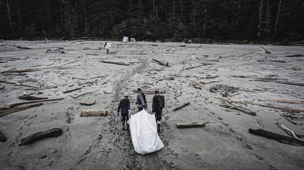 people pull debris from ocean