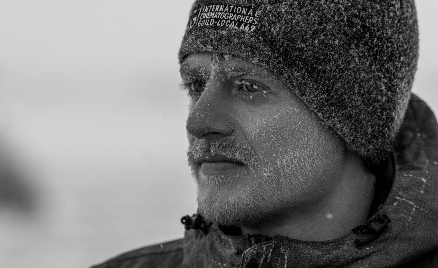 Close-up black and white photo of photographer Martin Gregus, who has snow in his beard