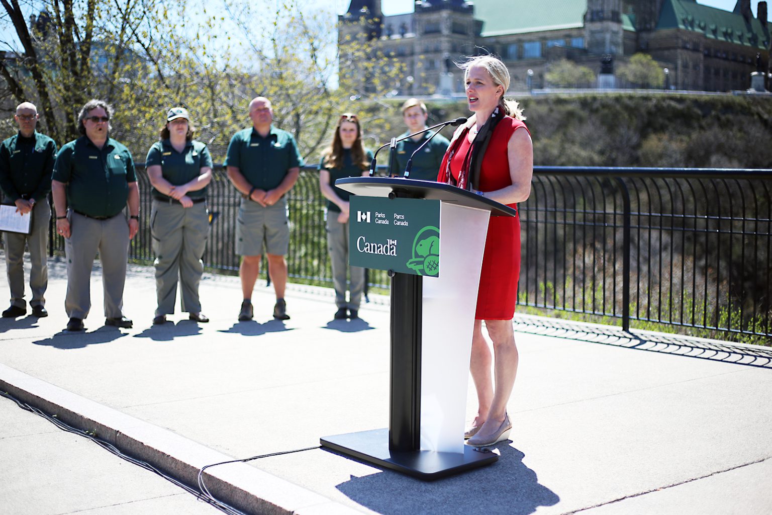 Parks Canada staff look on as Catherine McKenna announces the report on the Minister's Roundtable on Parks at Major's Hill Park in Ottawa.