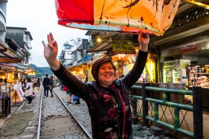 A woman smiles as she releases a paper lantern inscribed with prayers during the 2017 Taiwan Lantern Festival
