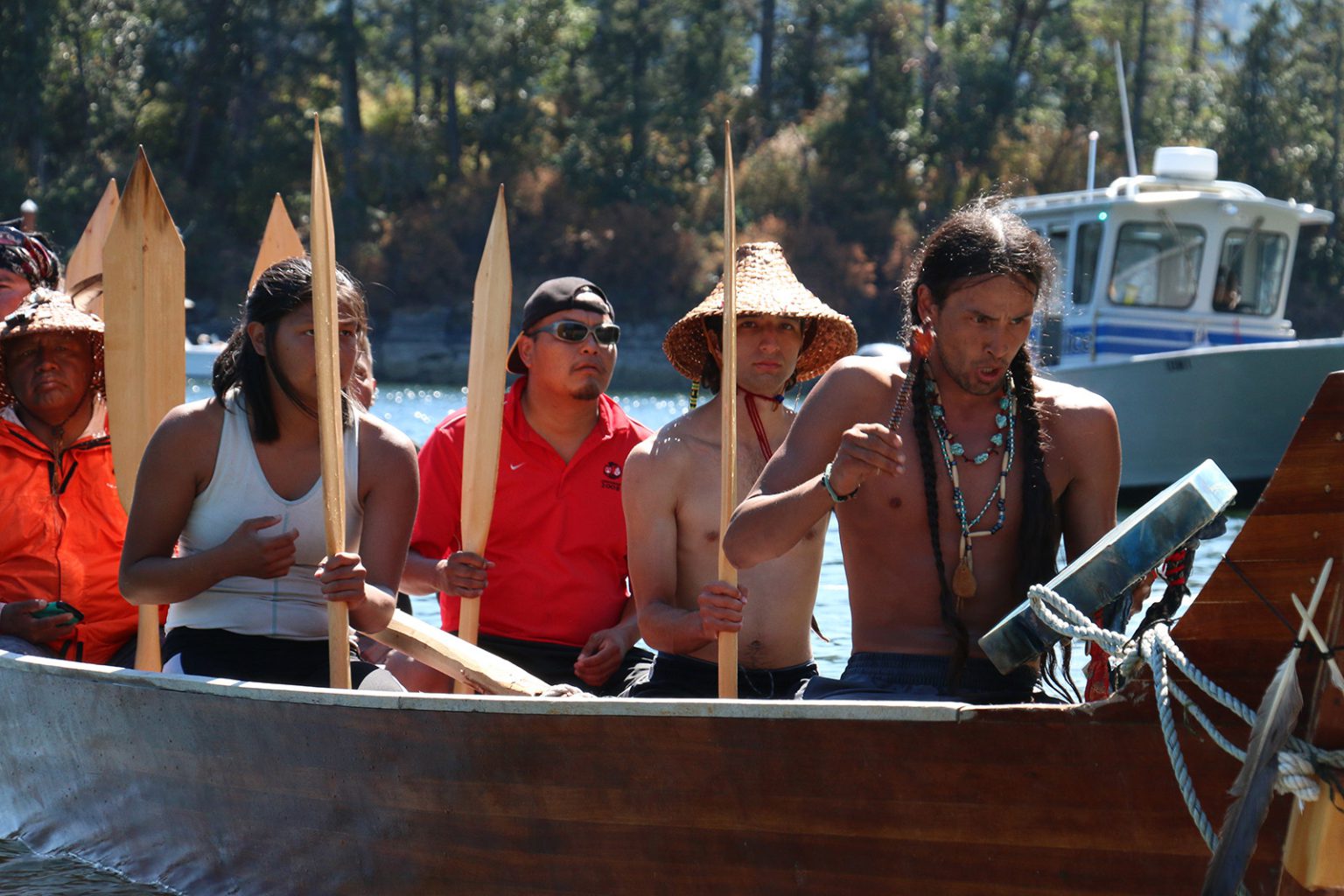 The Quinault crew sings a spirited paddle song as they arrive on Stz?uminus shores.