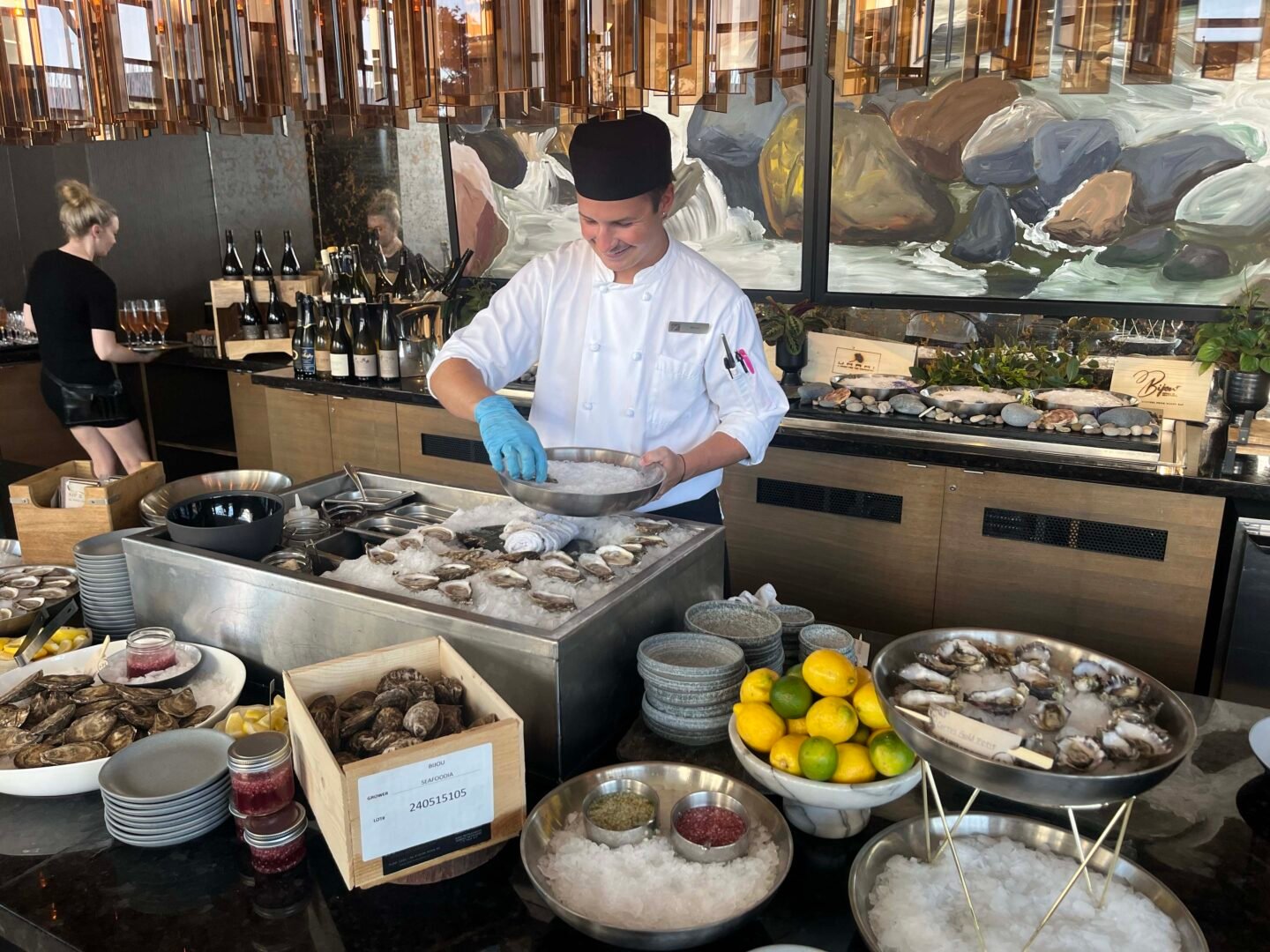 A sous chef prepares oysters on a platter