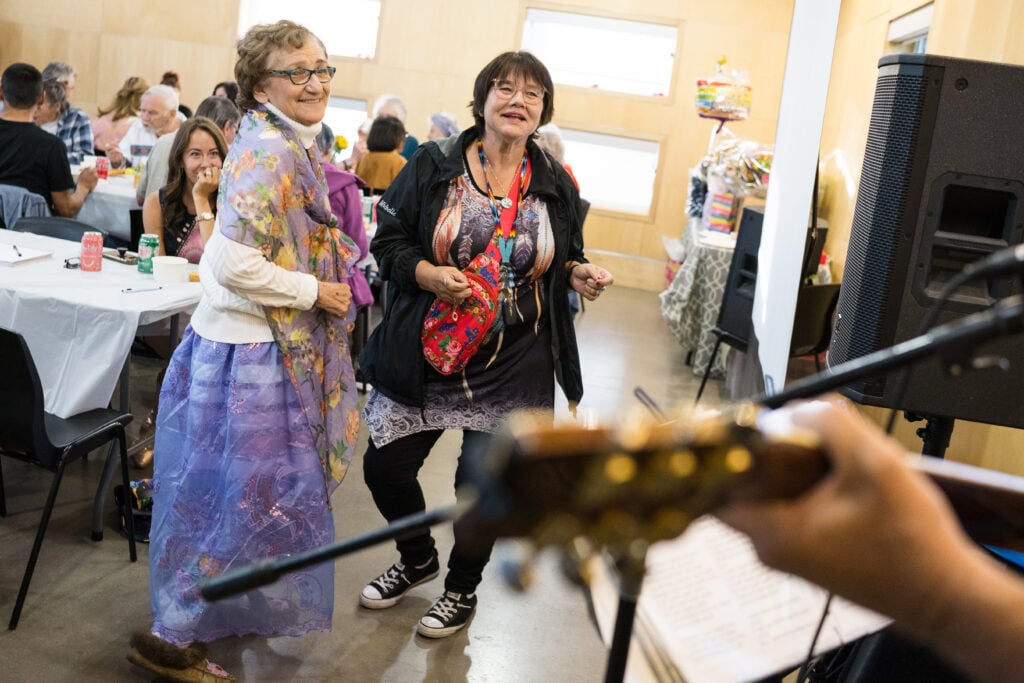 Maggie dances with a friend to live music