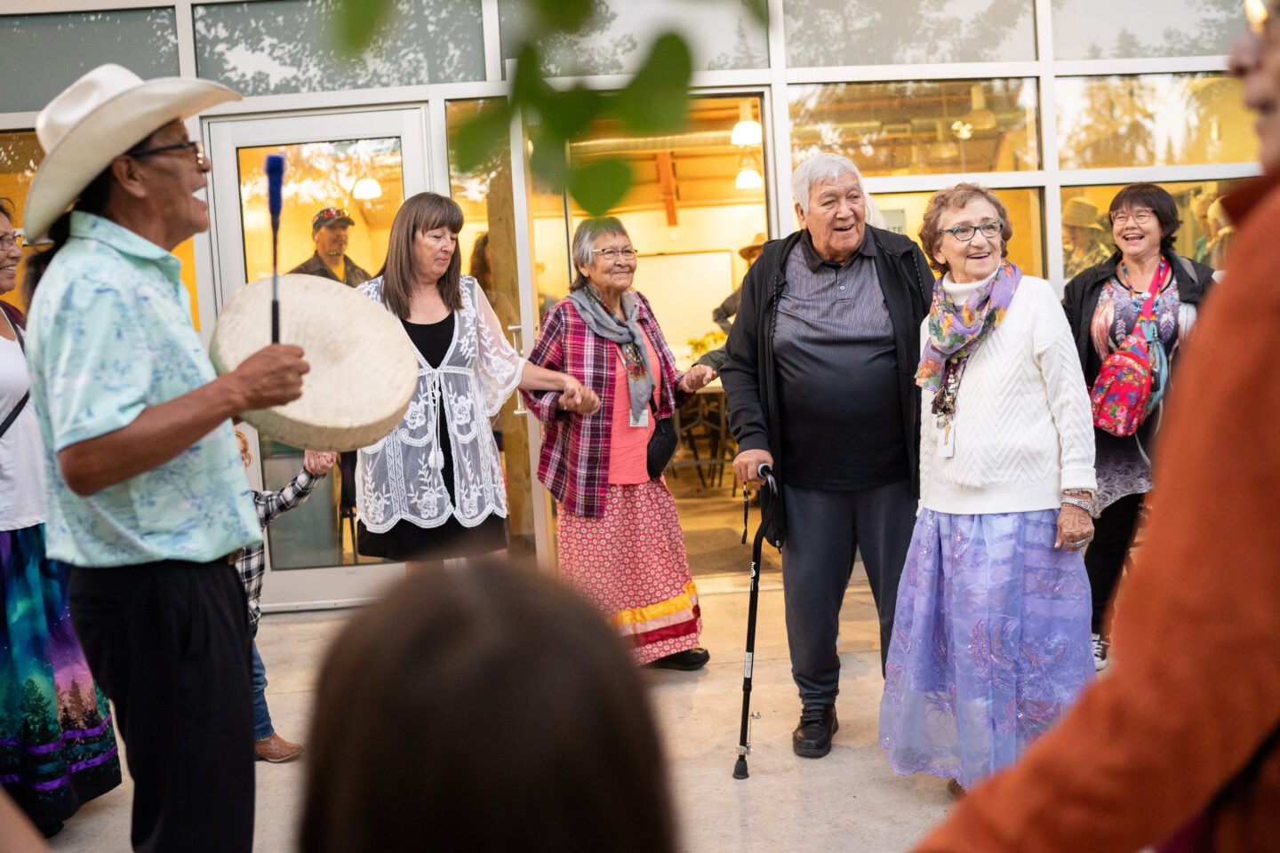 Maggie Hodgson stands in the middle of a circle of people dancing at her 80th birthday party