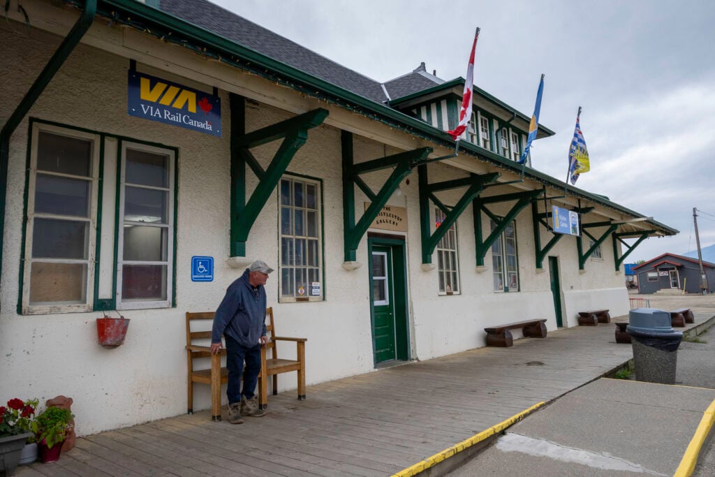 A man waits at a railway station