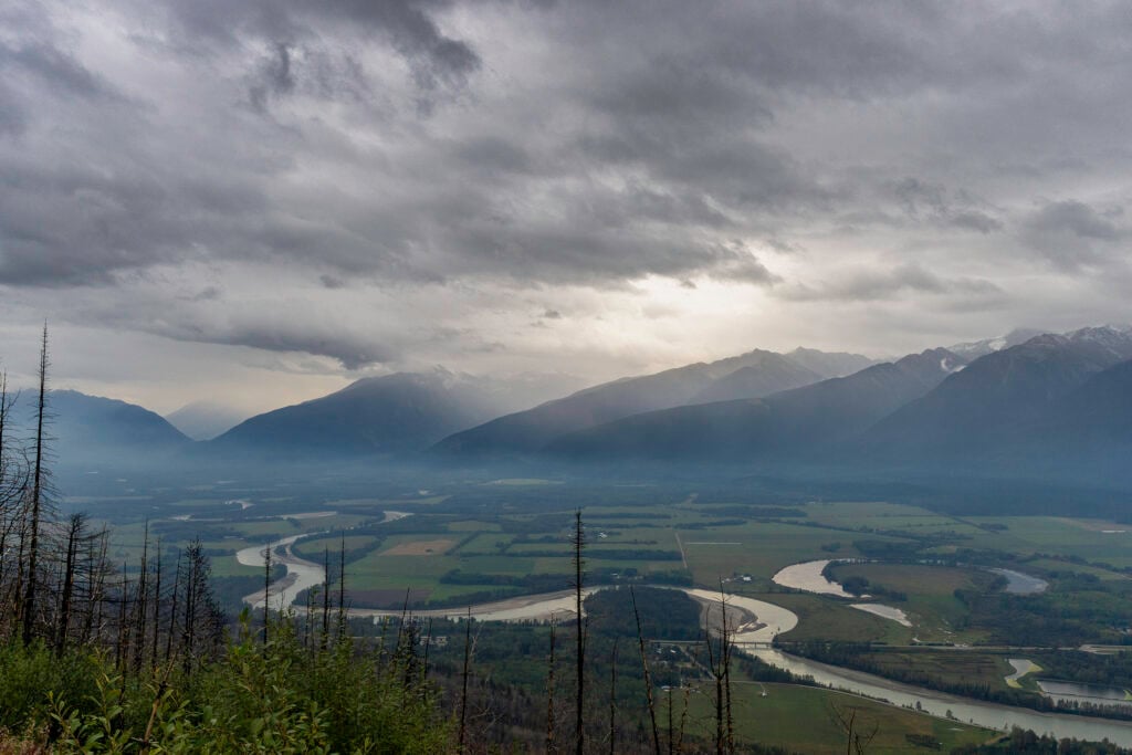 A view of a winding river in front of mountains